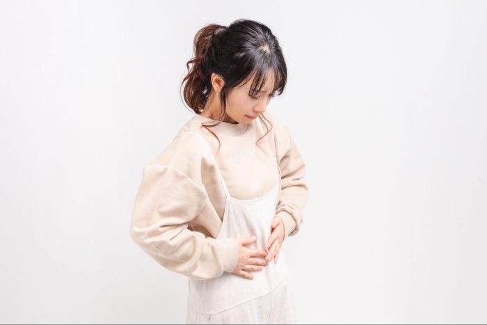 お腹を押さえる女性
